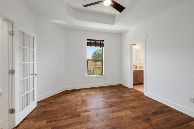 102 Rivulet Ln, Austin, TX 78738 - unfurnished bedroom with a raised ceiling, wood finished floors, ensuite bath, and a ceiling fan