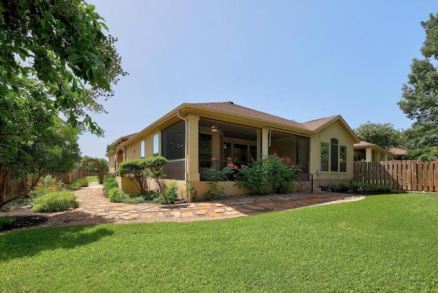 102 Rivulet Ln, Austin, TX 78738 - back of property featuring a fenced backyard, stucco siding, and a sunroom