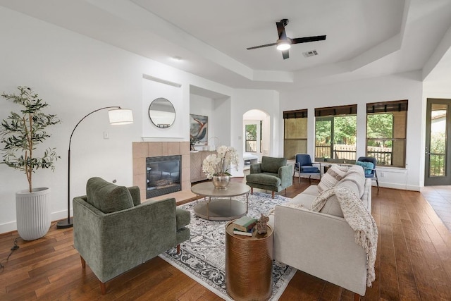 102 Rivulet Ln, Austin, TX 78738 - living room with a tray ceiling, a ceiling fan, wood-type flooring, and a tiled fireplace
