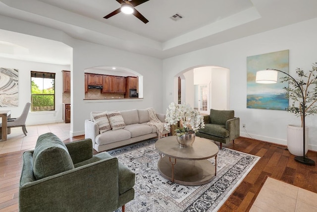 102 Rivulet Ln, Austin, TX 78738 - living area with a tray ceiling, a ceiling fan, arched walkways, and light wood-style flooring