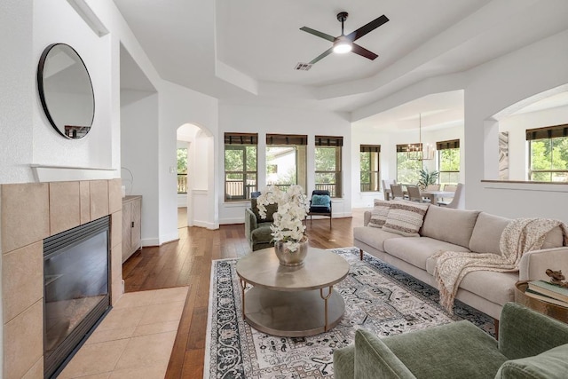 102 Rivulet Ln, Austin, TX 78738 - living room with a raised ceiling, wood-type flooring, arched walkways, a fireplace, and a ceiling fan