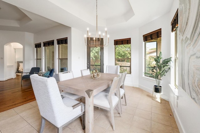 102 Rivulet Ln, Austin, TX 78738 - dining area with a raised ceiling, arched walkways, a chandelier, and light tile patterned floors