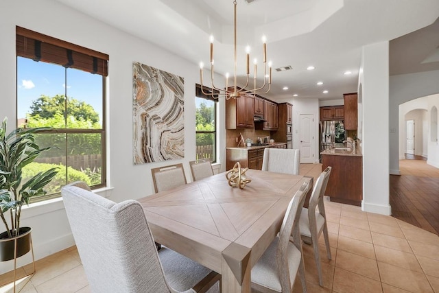 102 Rivulet Ln, Austin, TX 78738 - dining space featuring arched walkways, light tile patterned flooring, a chandelier, and recessed lighting