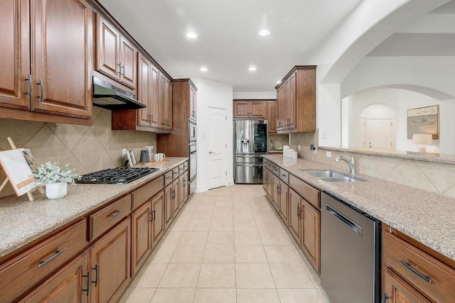 102 Rivulet Ln, Austin, TX 78738 - kitchen with stainless steel appliances, under cabinet range hood, decorative backsplash, light stone counters, and recessed lighting