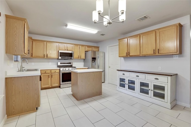 1608 Melibee Trl, Austin, TX 78748 - kitchen with appliances with stainless steel finishes, a chandelier, a kitchen island, light countertops, and light brown cabinets