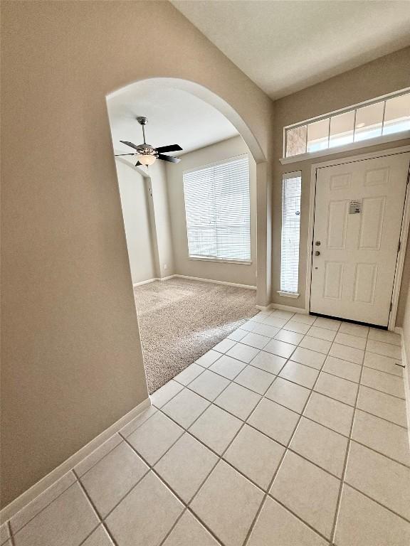 1907 Rutherford Dr, Leander, TX 78641 - foyer with arched walkways, light tile patterned floors, and a ceiling fan