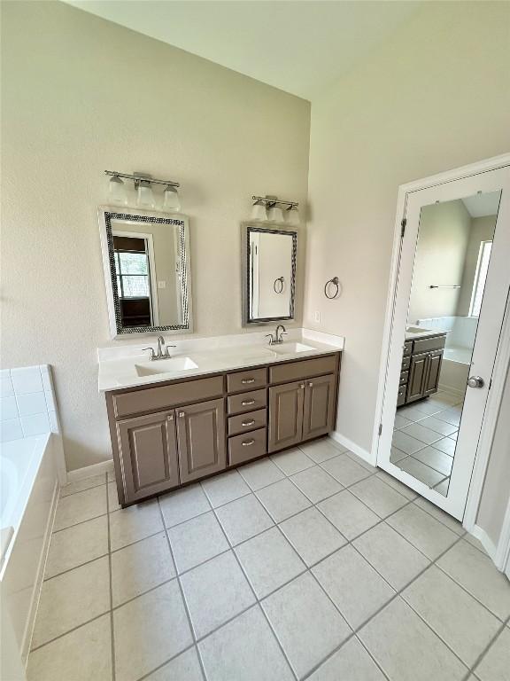 1907 Rutherford Dr, Leander, TX 78641 - full bathroom with double vanity, a bath, and tile patterned floors