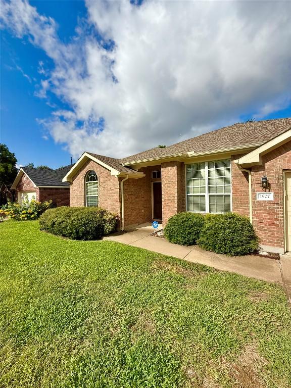 1907 Rutherford Dr, Leander, TX 78641 - single story home featuring brick siding, a front yard, and a garage