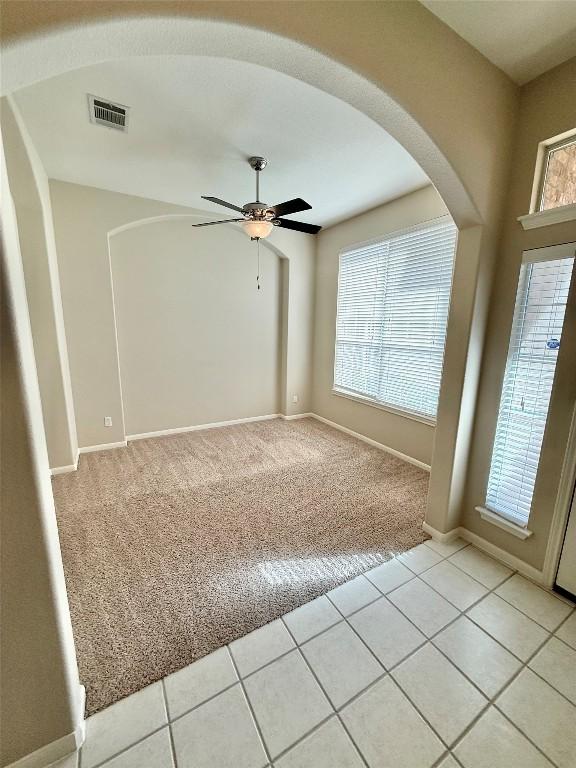 1907 Rutherford Dr, Leander, TX 78641 - spare room with light colored carpet, a ceiling fan, arched walkways, and light tile patterned floors