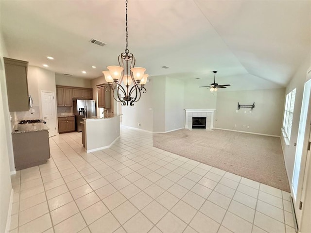1907 Rutherford Dr, Leander, TX 78641 - unfurnished living room with ceiling fan, light tile patterned floors, a fireplace, a chandelier, and recessed lighting