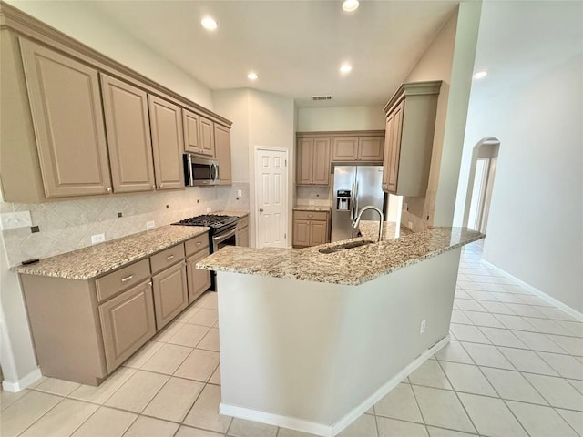 1907 Rutherford Dr, Leander, TX 78641 - kitchen with appliances with stainless steel finishes, arched walkways, a peninsula, decorative backsplash, and recessed lighting
