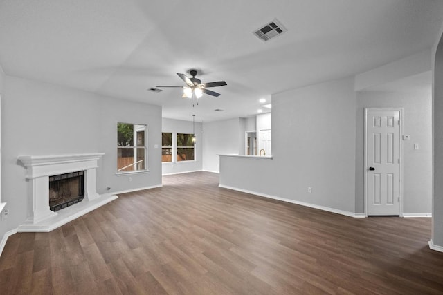 8943 W Hove Loop, Austin, TX 78749 - unfurnished living room with ceiling fan, wood finished floors, and a fireplace with raised hearth