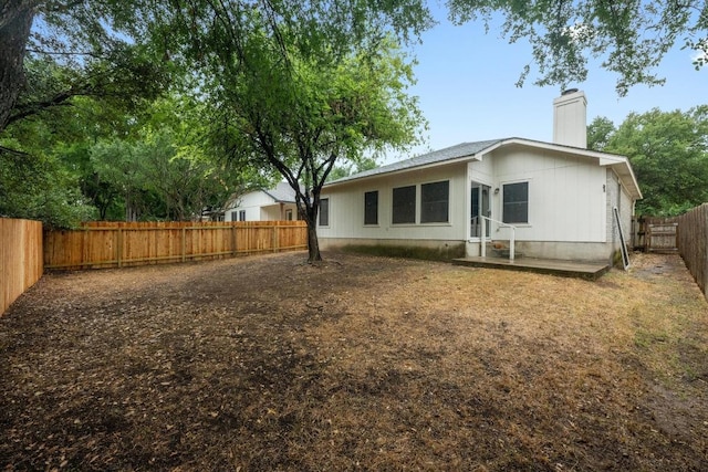 8943 W Hove Loop, Austin, TX 78749 - back of house with a chimney and a fenced backyard