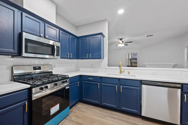8943 W Hove Loop, Austin, TX 78749 - kitchen featuring appliances with stainless steel finishes, blue cabinets, a ceiling fan, and light wood finished floors