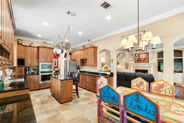 5100 Hadle Cv, Austin, TX 78730 - kitchen featuring appliances with stainless steel finishes, a chandelier, dark countertops, arched walkways, and crown molding