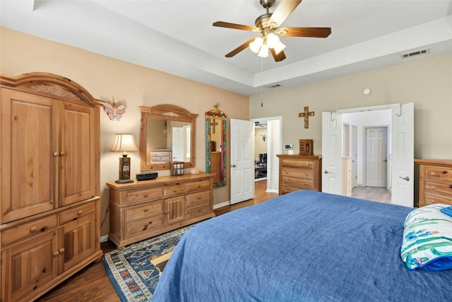 5100 Hadle Cv, Austin, TX 78730 - bedroom with wood finished floors, a tray ceiling, and a ceiling fan