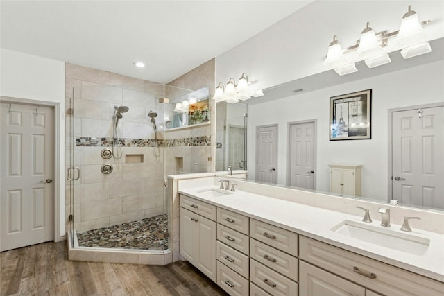 5100 Hadle Cv, Austin, TX 78730 - bathroom with double vanity, a stall shower, wood finished floors, and recessed lighting