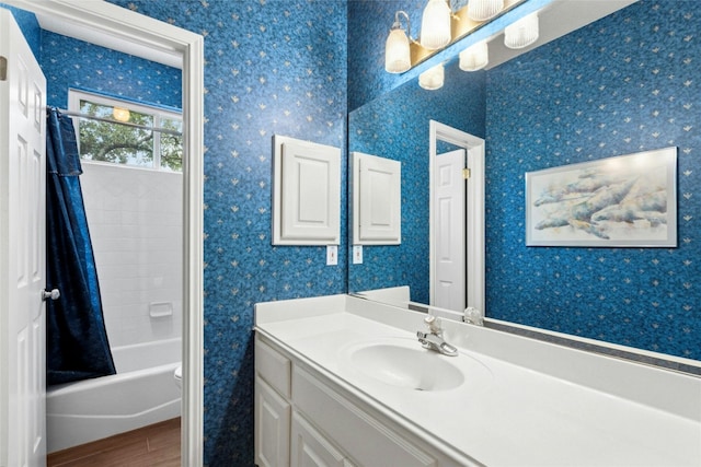 5100 Hadle Cv, Austin, TX 78730 - full bath featuring wood finished floors, vanity, wallpapered walls, and shower / tub combo