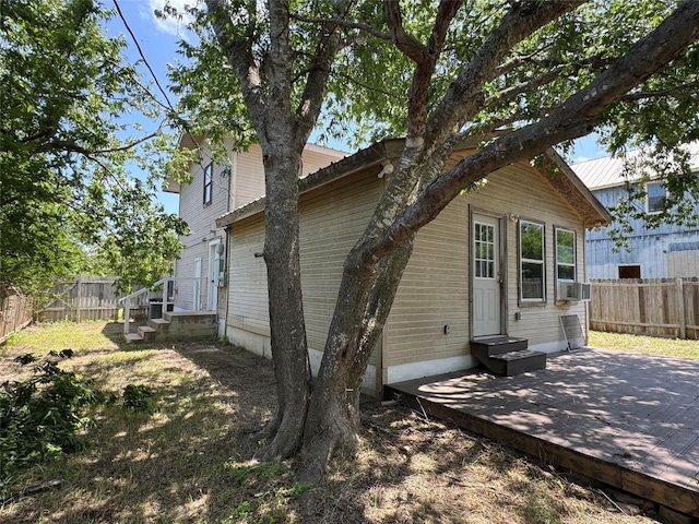 572 Eastern Ave, Bertram, TX 78605 - back of property with a fenced backyard, entry steps, a wooden deck, and cooling unit