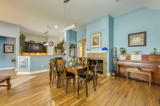307 N Rainbow Bridge Dr, Cedar Park, TX 78613 - dining space featuring a tile fireplace, light wood-style flooring, and arched walkways