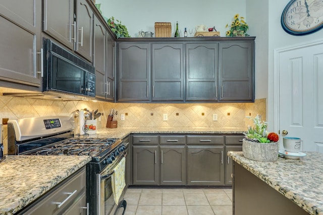 307 N Rainbow Bridge Dr, Cedar Park, TX 78613 - kitchen with stainless steel range with gas stovetop, black microwave, light tile patterned floors, and light stone counters