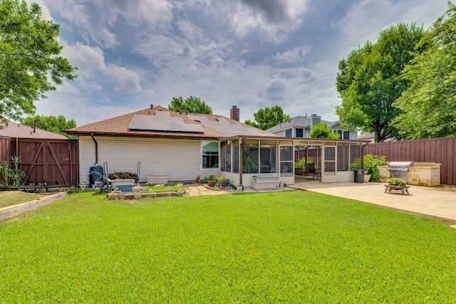 307 N Rainbow Bridge Dr, Cedar Park, TX 78613 - back of house with a sunroom, roof mounted solar panels, a patio area, a fenced backyard, and a chimney