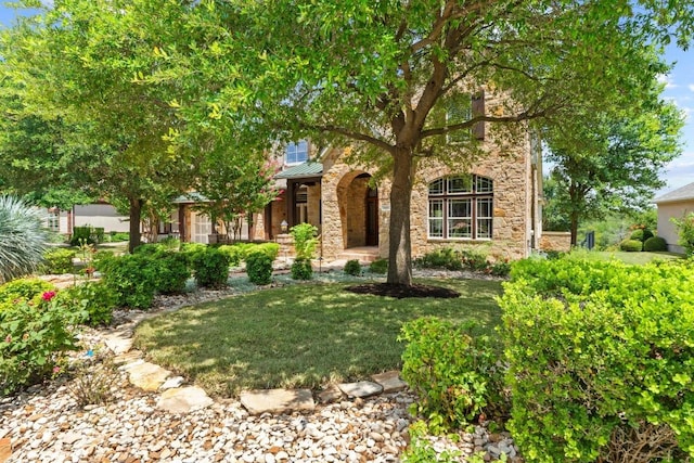 908 Lakewood Hills Ter, Austin, TX 78732 - view of property hidden behind natural elements with stone siding, a front lawn, a standing seam roof, and a metal roof