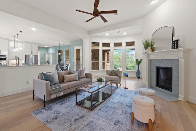 908 Lakewood Hills Ter, Austin, TX 78732 - living area with light wood-type flooring, ceiling fan, recessed lighting, and a tiled fireplace