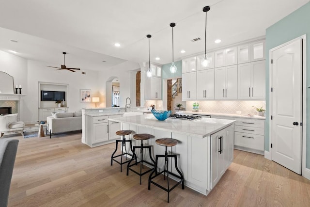 908 Lakewood Hills Ter, Austin, TX 78732 - kitchen featuring arched walkways, ceiling fan, white cabinetry, light wood-style floors, and recessed lighting