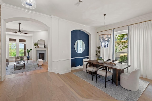 908 Lakewood Hills Ter, Austin, TX 78732 - dining space with arched walkways, ceiling fan, wood finished floors, crown molding, and a chandelier