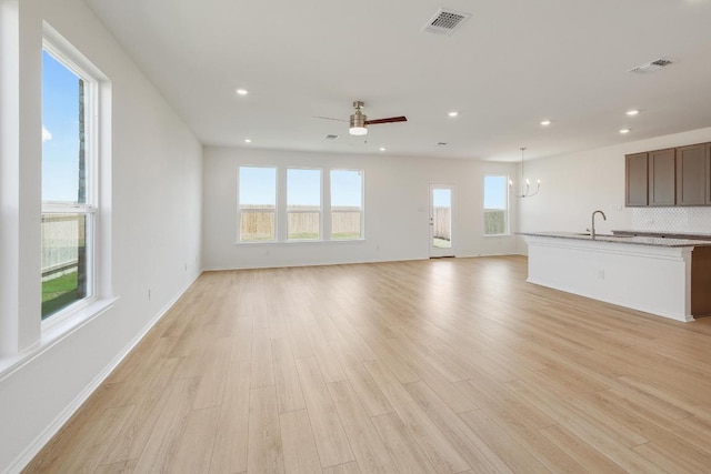 4852 Mozzafiato Ln, Round Rock, TX 78665 - unfurnished living room with a chandelier, recessed lighting, light wood-style flooring, and a ceiling fan