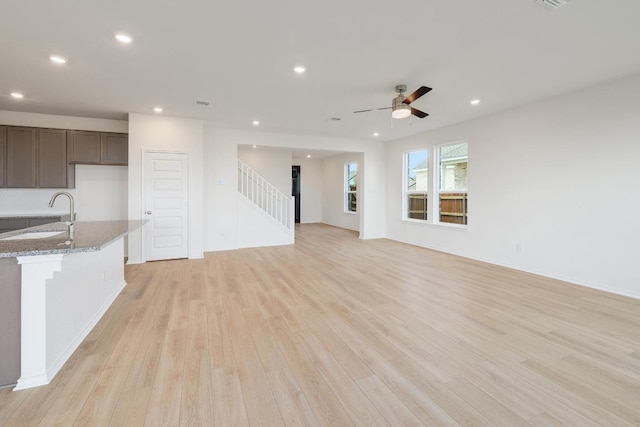 4852 Mozzafiato Ln, Round Rock, TX 78665 - unfurnished living room with light wood-style floors, stairs, ceiling fan, and recessed lighting