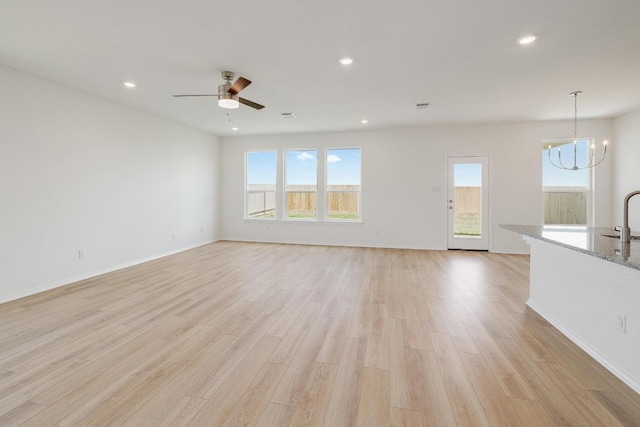 4852 Mozzafiato Ln, Round Rock, TX 78665 - unfurnished living room with a chandelier, light wood-style floors, recessed lighting, and ceiling fan