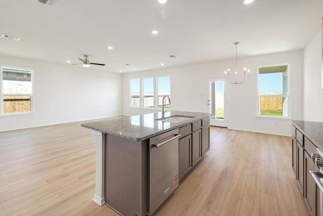 4852 Mozzafiato Ln, Round Rock, TX 78665 - kitchen featuring dishwasher, light wood-style flooring, light stone countertops, a chandelier, and healthy amount of natural light