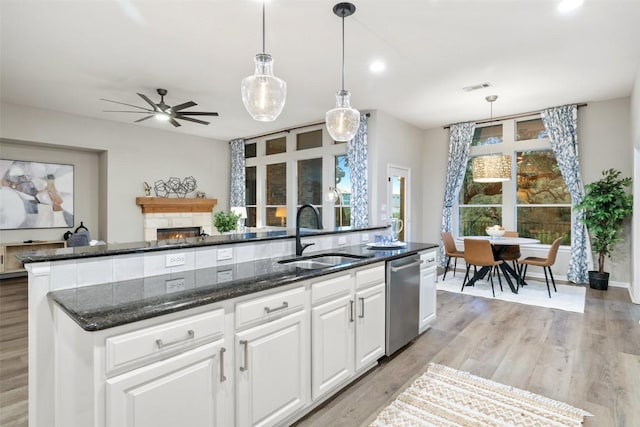 128 Big Sky Cv, Austin, TX 78737 - kitchen featuring stainless steel dishwasher, ceiling fan, dark stone counters, white cabinetry, and light wood-type flooring