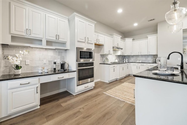 128 Big Sky Cv, Austin, TX 78737 - kitchen with appliances with stainless steel finishes, white cabinetry, recessed lighting, light wood-style floors, and backsplash