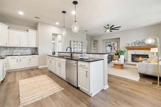 128 Big Sky Cv, Austin, TX 78737 - kitchen featuring dishwasher, a stone fireplace, recessed lighting, a ceiling fan, and white cabinets