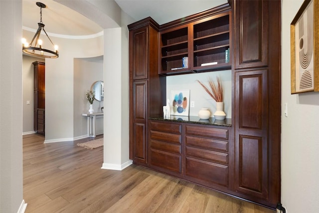 128 Big Sky Cv, Austin, TX 78737 - detailed view of wood finished floors, arched walkways, crown molding, and a chandelier