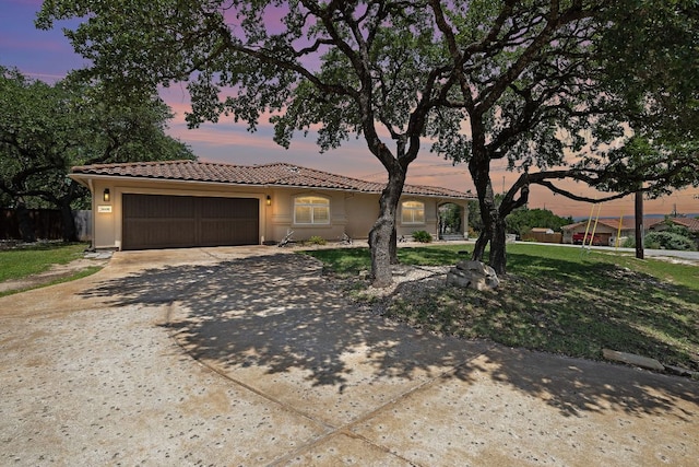 3608 Rockefeller Cv, Lago Vista, TX 78645 - mediterranean / spanish home with an attached garage, driveway, a tiled roof, and stucco siding