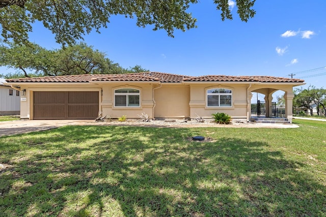 3608 Rockefeller Cv, Lago Vista, TX 78645 - mediterranean / spanish house with an attached garage, a tile roof, stucco siding, driveway, and a front lawn