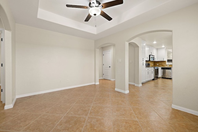 3608 Rockefeller Cv, Lago Vista, TX 78645 - spare room featuring a ceiling fan, arched walkways, a tray ceiling, light tile patterned flooring, and recessed lighting