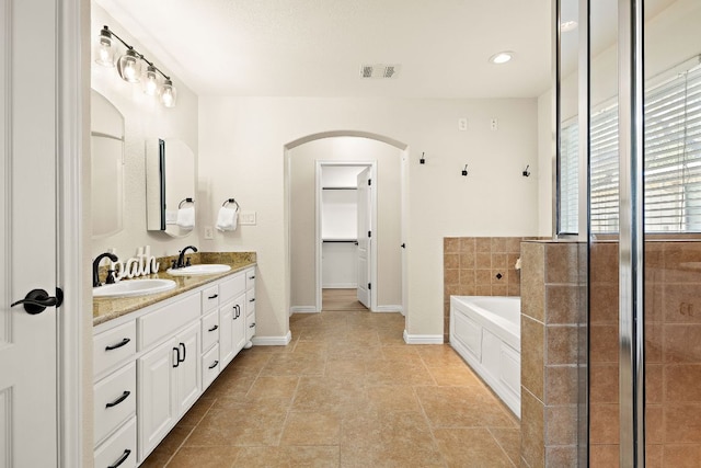 3608 Rockefeller Cv, Lago Vista, TX 78645 - full bathroom with double vanity, a garden tub, a spacious closet, and a tile shower