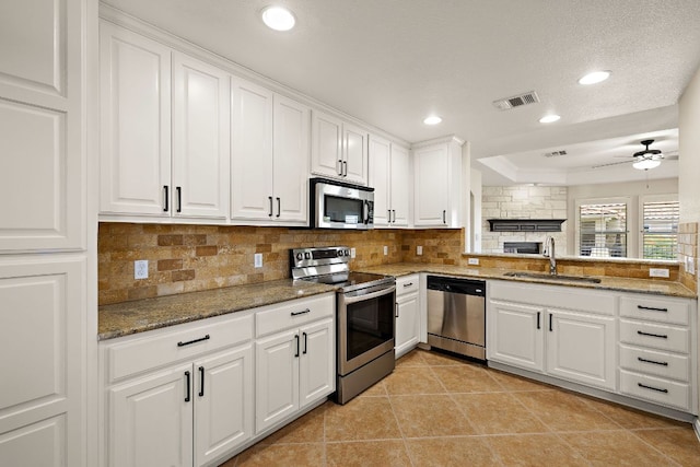 3608 Rockefeller Cv, Lago Vista, TX 78645 - kitchen with stainless steel appliances, backsplash, white cabinets, ceiling fan, and light tile patterned floors