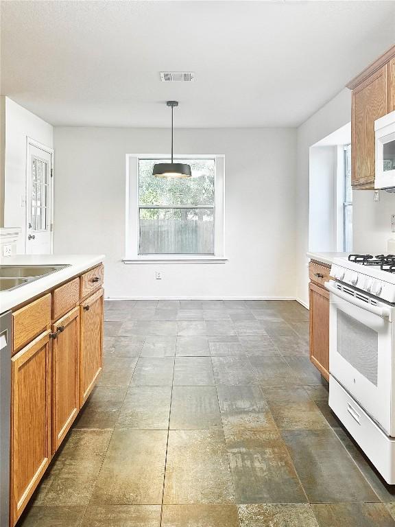 2306 Wilma Rudolph Rd, Austin, TX 78748 - kitchen with white appliances, light countertops, and hanging light fixtures
