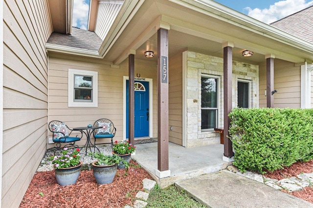 157 Old Firetower Rd, Bastrop, TX 78602 - view of exterior entry featuring a shingled roof, covered porch, and stone siding