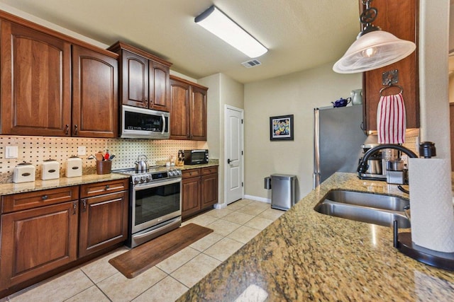 157 Old Firetower Rd, Bastrop, TX 78602 - kitchen with stainless steel appliances, decorative backsplash, light tile patterned floors, and light stone counters