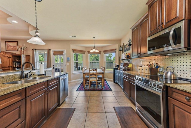 157 Old Firetower Rd, Bastrop, TX 78602 - kitchen featuring stainless steel appliances, a chandelier, tasteful backsplash, decorative light fixtures, and light stone counters