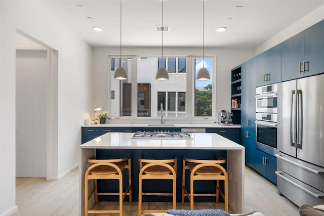 3100 Menchaca Rd Unit 24, Austin, TX 78704 - kitchen with stainless steel appliances, blue cabinets, light wood-style floors, light countertops, and recessed lighting