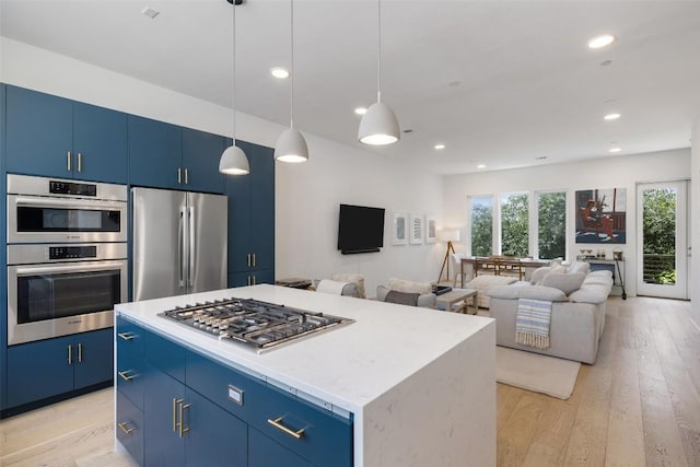 3100 Menchaca Rd Unit 24, Austin, TX 78704 - kitchen with appliances with stainless steel finishes, blue cabinetry, light wood finished floors, a center island, and recessed lighting