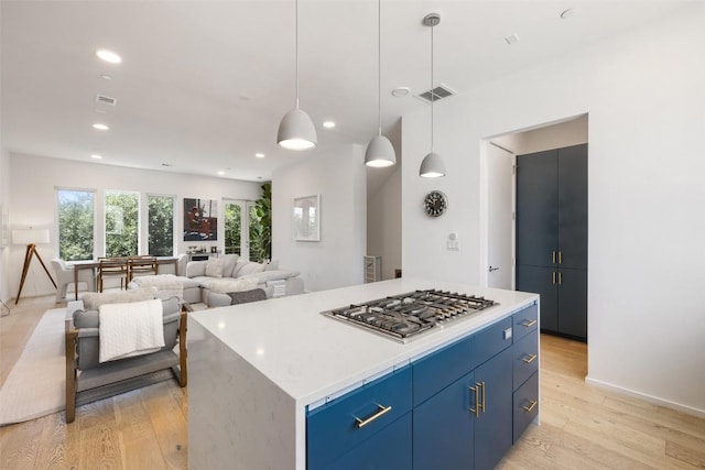 3100 Menchaca Rd Unit 24, Austin, TX 78704 - kitchen with stainless steel gas stovetop, blue cabinetry, light wood-style flooring, light countertops, and recessed lighting